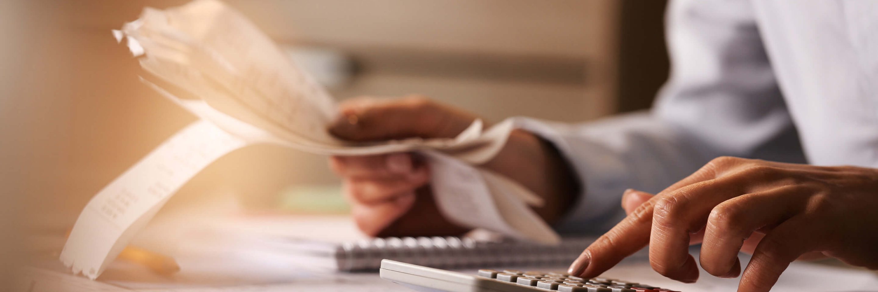 Closeup economist using calculator while going through bills taxes office1