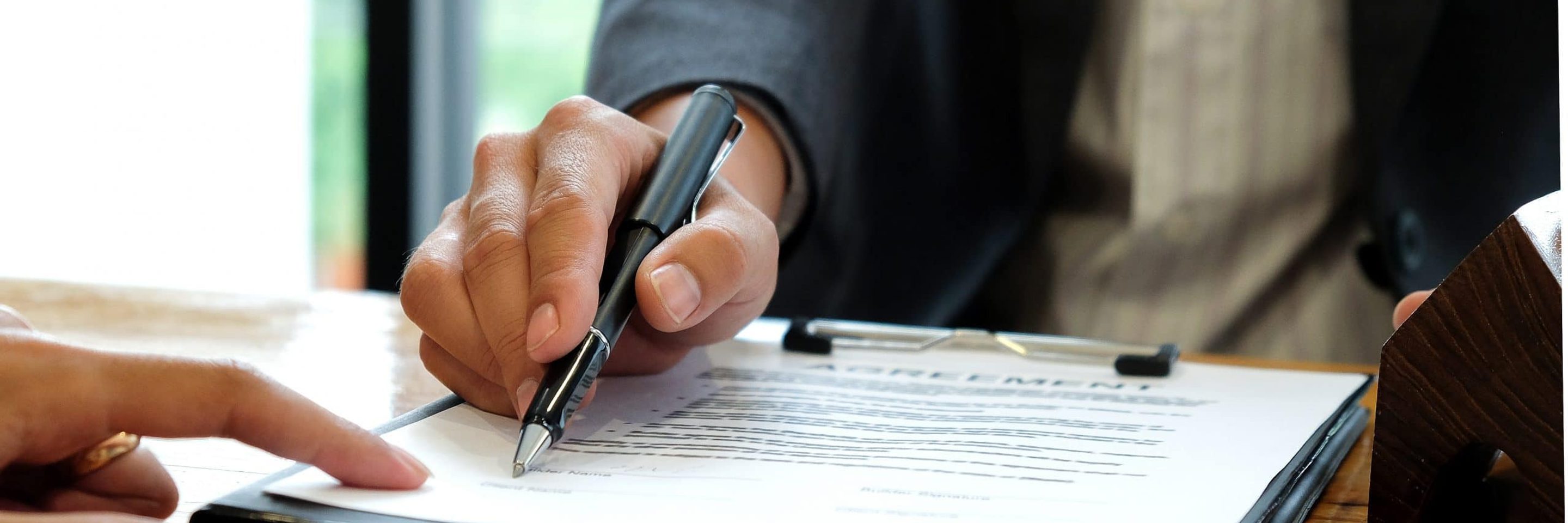 Businessmen selling the house pointing at signing EMNZWTG scaled