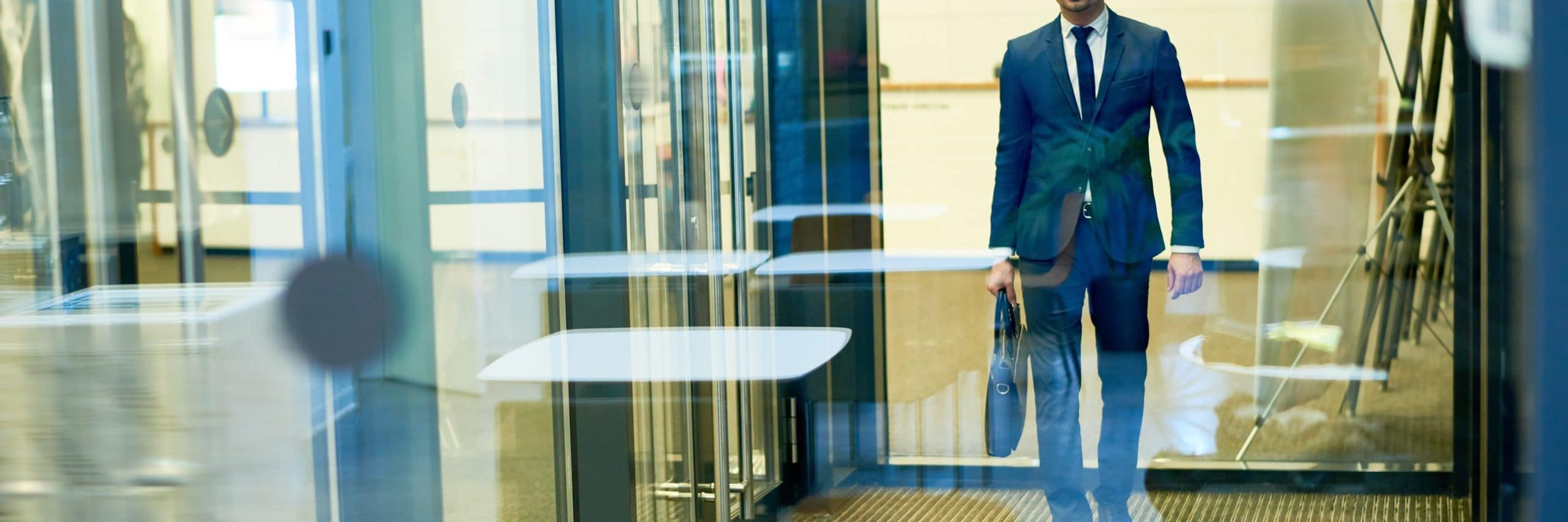 Handsome businessman leaving building 7 RD53 SU scaled