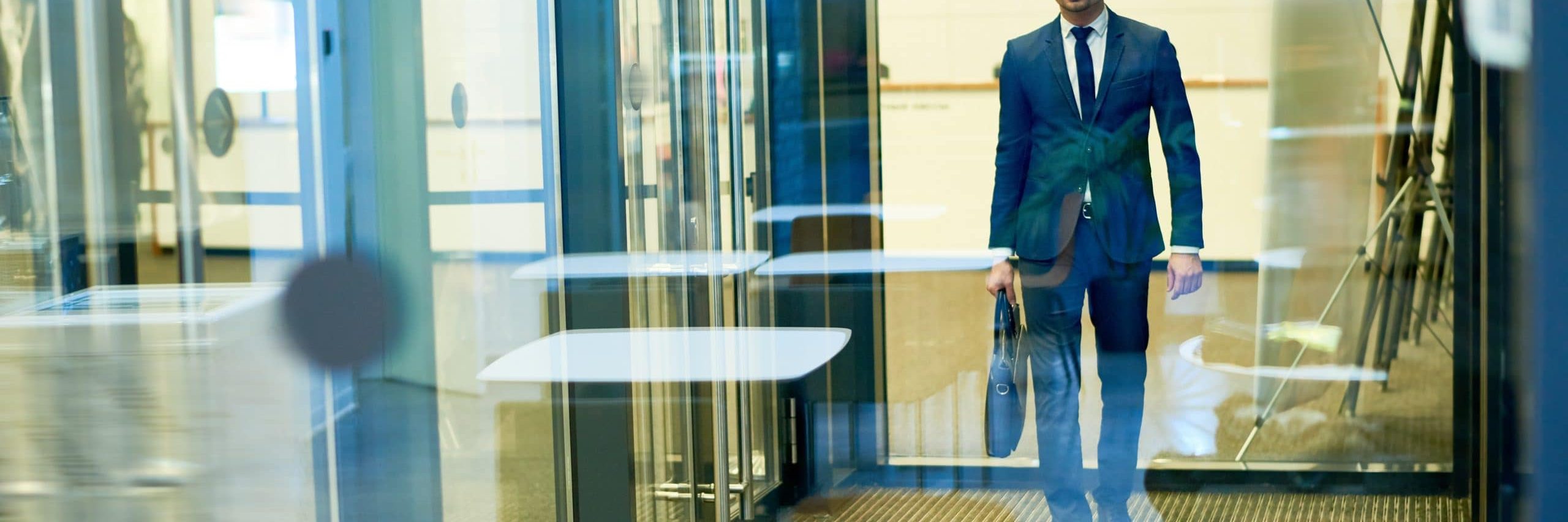 Handsome businessman leaving building 7 RD53 SU scaled