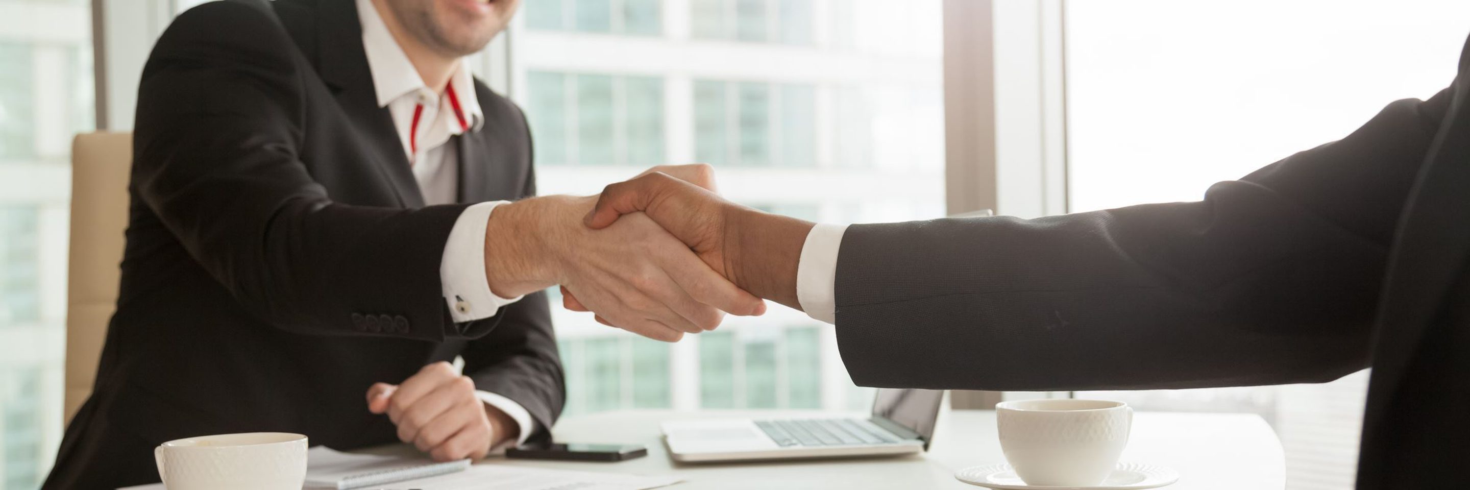 Partners shaking hands after singing contract Copy