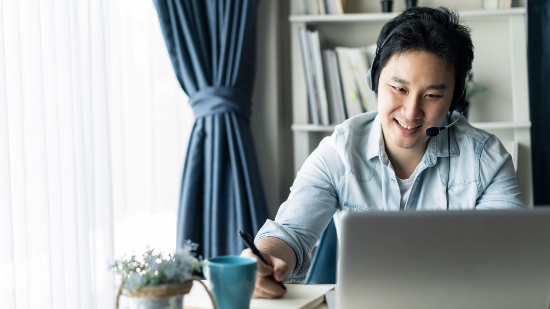 Asian man laptop teleconference zoom online meeting working from home hybrid